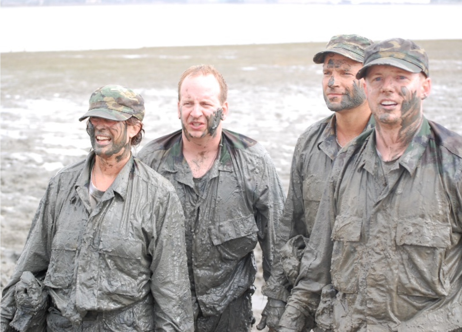 Pictured: Mud-covered trainees take a break from training during Navy Seals' Leadership Under Fire Program.